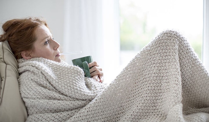 Erkältete Frau trinkt Tee Erhöhte Körpertemperatur und Fieber