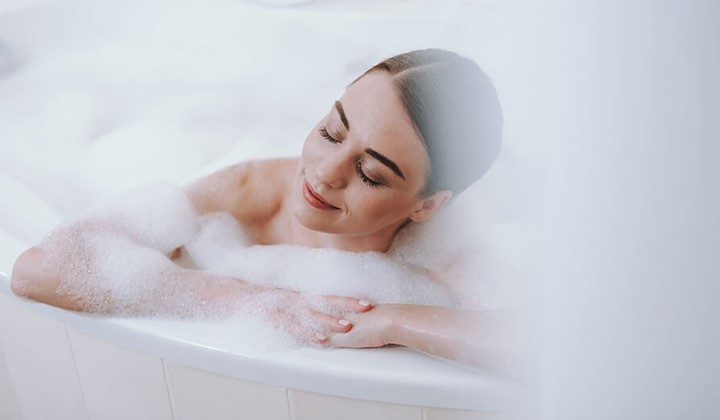 Frau in Badewanne Erkältungsbad gegen Gliederschmerzen